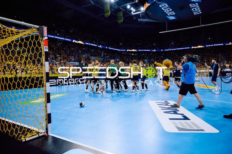 Feiernde Spieler der Rhein Neckar Löwen auf dem Spielfeld.