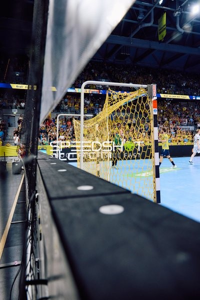 Spielszene mit Blick auf das Handballtor und die Halle.