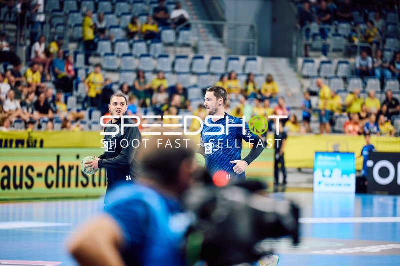 Zwei Spieler von THW Kiel diskutieren auf dem Spielfeld.