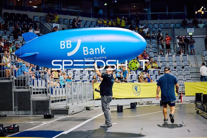 Ein Werbeluftschiff wird in der Halle getragen.