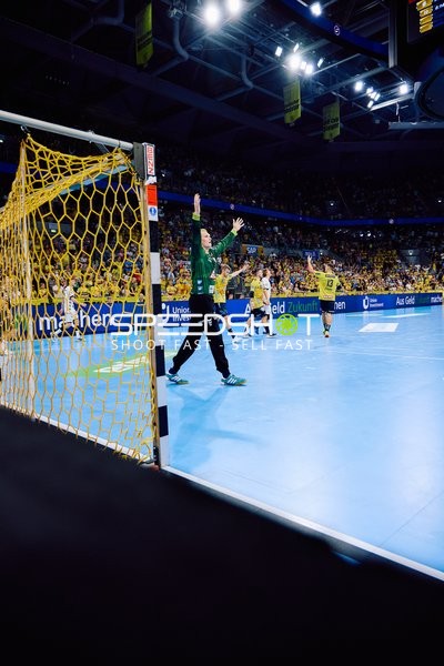 Ein Torwart steht im Tor, bereit einen Wurf abzuwehren.