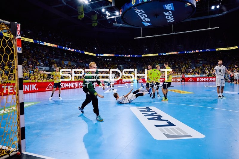 Ein Spieler von THW Kiel fällt auf den Boden, während David Späth von Rhein Neckar Löwen im Tor steht.