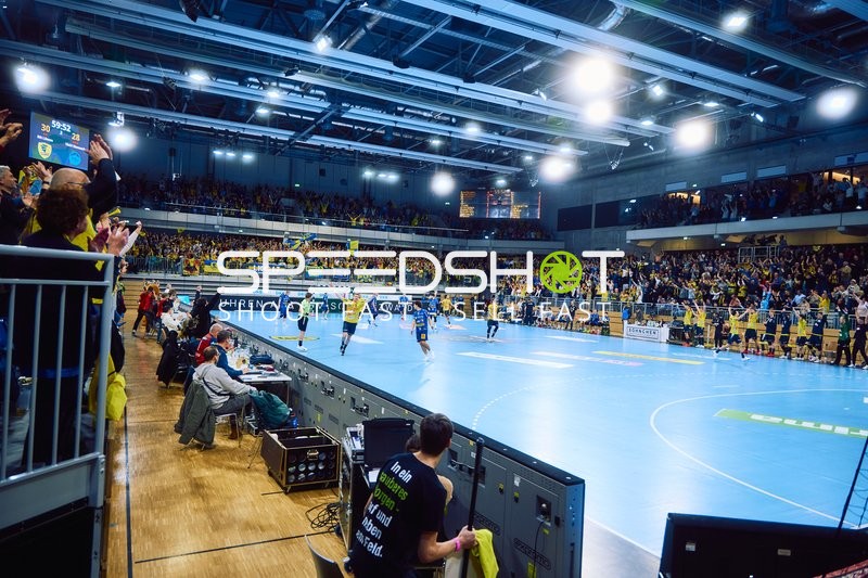 Spieler feiern vor den Zuschauern in der Halle.