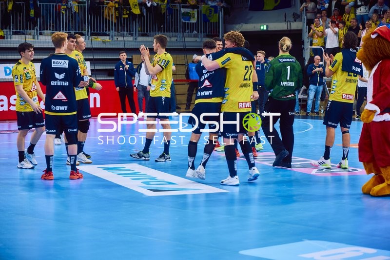 Spieler von Rhein Neckar Löwen feiern auf dem Spielfeld.