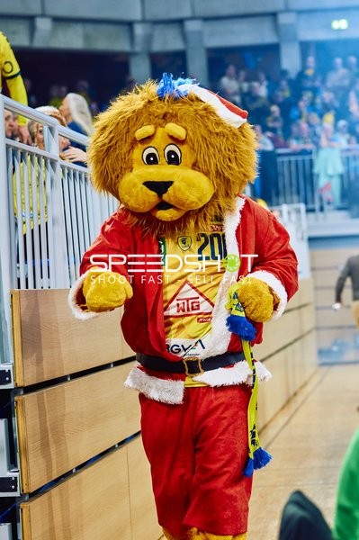 Ein Maskottchen in einem weihnachtlichen Kostüm läuft entlang der Tribüne.
