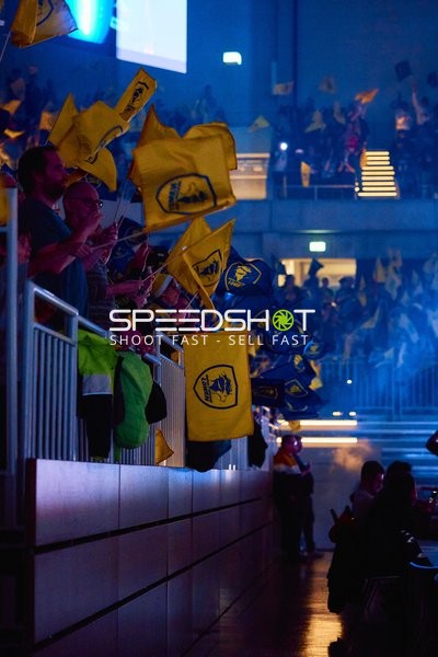 Fans im Publikum schwenken Fahnen.