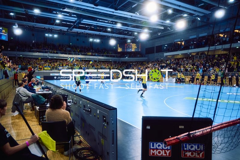 Ein Handballspiel wird in einer Halle gespielt.
