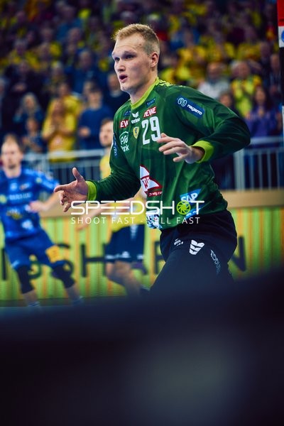 Ein Spieler in grünem Trikot von Rhein Neckar Löwen steht bereit für eine Aktion.