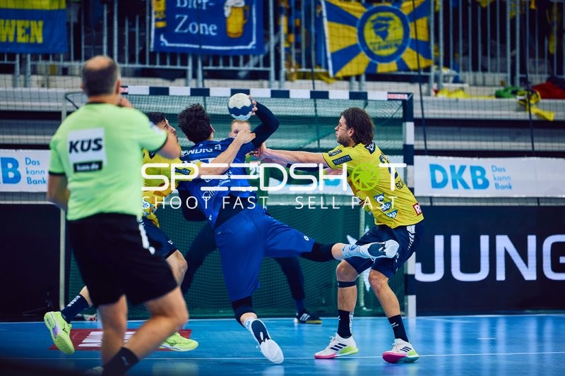 Ein Spieler von ThSV Eisenach greift mit dem Ball an und wird von zwei Spielern der Rhein Neckar Löwen verteidigt.