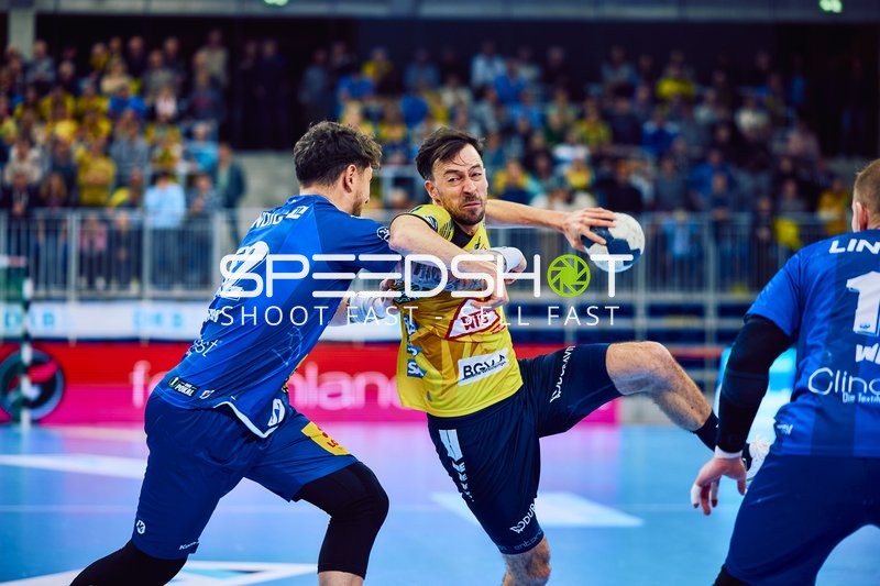 Ein Spieler der Rhein Neckar Löwen versucht, den Ball gegen die Abwehr von ThSV Eisenach zu werfen.