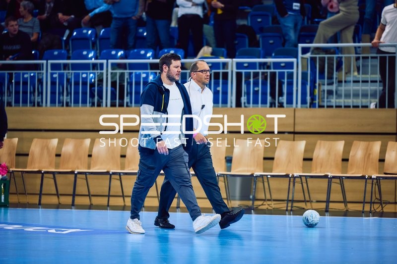 Zwei Männer gehen über das Spielfeld.