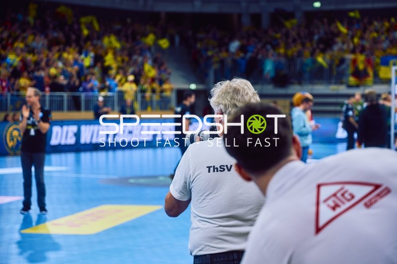 Ein Fotograf auf dem Spielfeld macht Bilder vom Spiel.