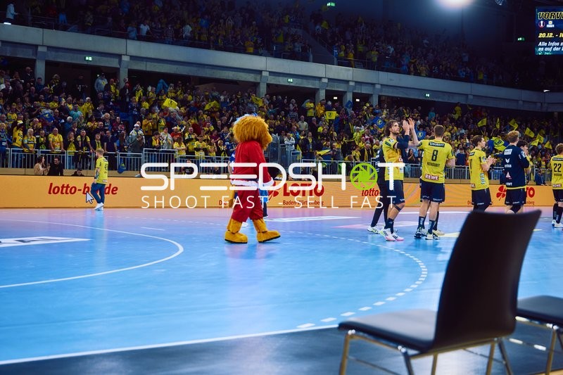 Spieler von Rhein Neckar Löwen feiern auf dem Spielfeld.