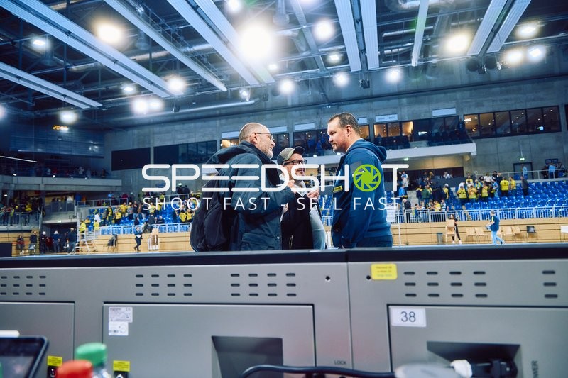 Personen diskutieren neben dem Spielfeld