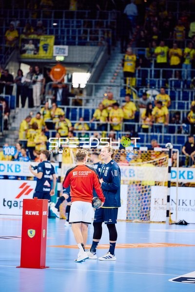 Spieler von Rhein Neckar Löwen und MT Melsungen begrüßen sich auf dem Spielfeld.