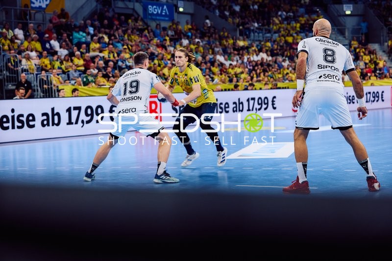 Juri Knorr von Rhein Neckar Löwen versucht, an zwei Verteidigern vorbeizukommen.