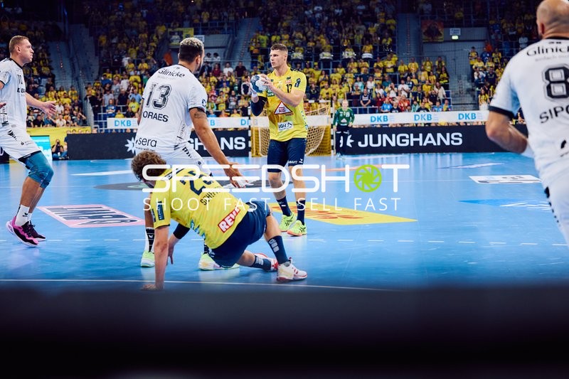 Ein Spieler von Rhein Neckar Löwen fällt auf den Boden, während ein Pass gespielt wird.