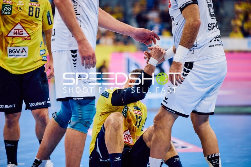 Spieler der Rhein Neckar Löwen wird beim Aufstehen unterstützt.