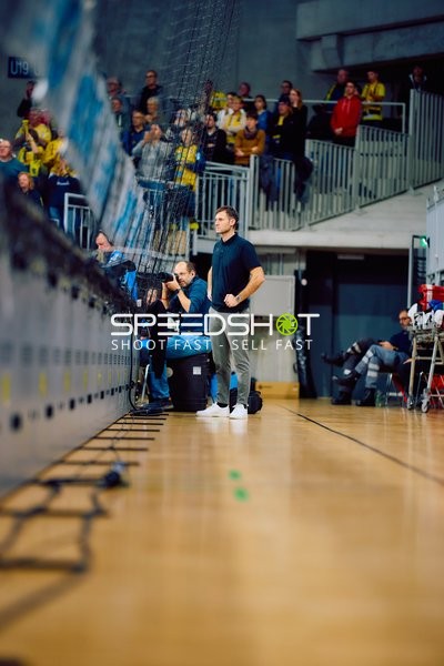 Ein Trainer oder Betreuer beobachtet das Spiel von der Seitenlinie.