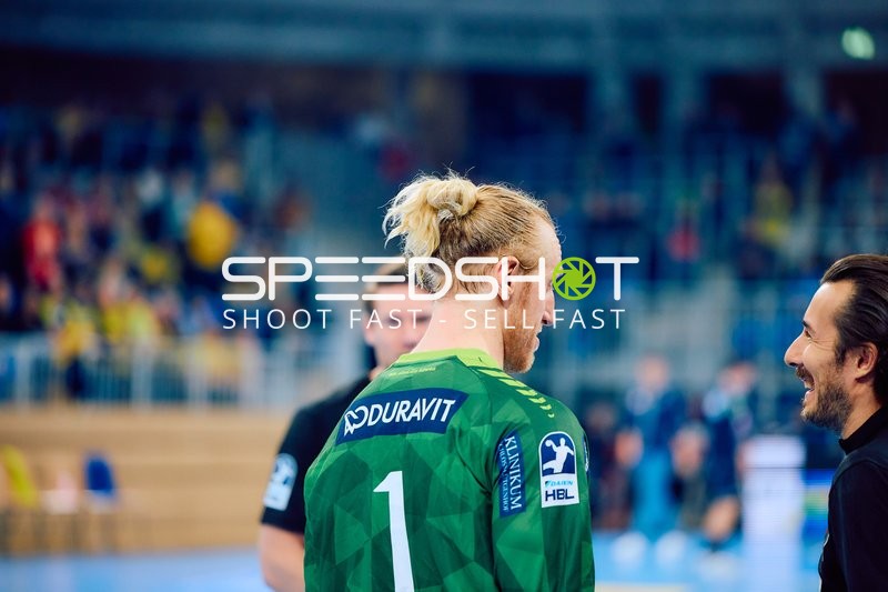 Spieler in grünem Trikot unterhält sich mit einer anderen Person.