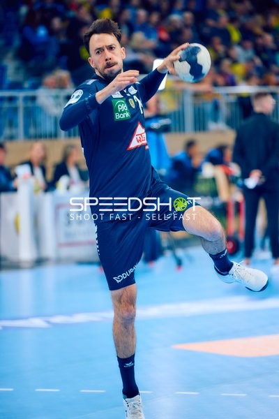 Ein Spieler im blauen Trikot beim Wurf.