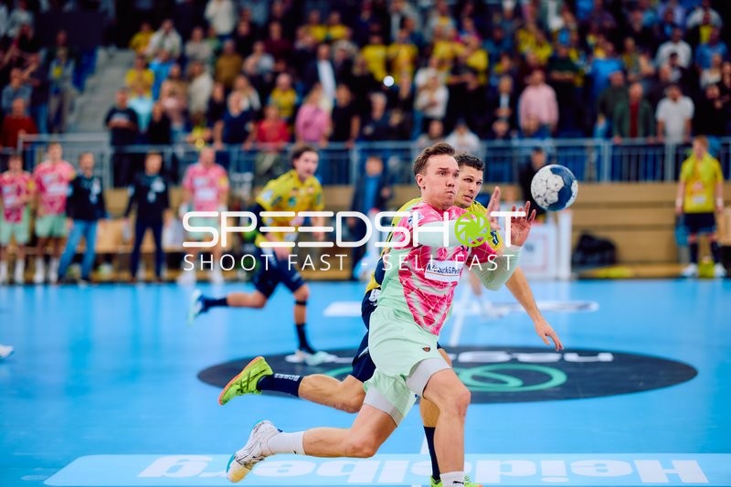 Lasse Andersson von den Füchsen Berlin passt den Ball unter Druck von Sebastian Heymann von Rhein Neckar Löwen.