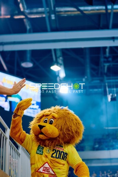 Ein Maskottchen der Rhein Neckar Löwen gibt einem Zuschauer High-Five.