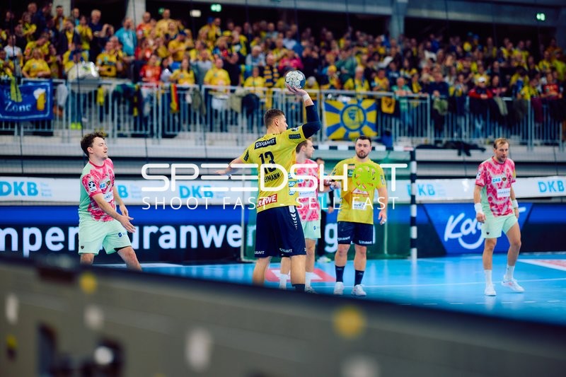 Ein Spieler der Rhein Neckar Löwen in gelbem Trikot bereitet sich darauf vor, den Ball zu werfen.