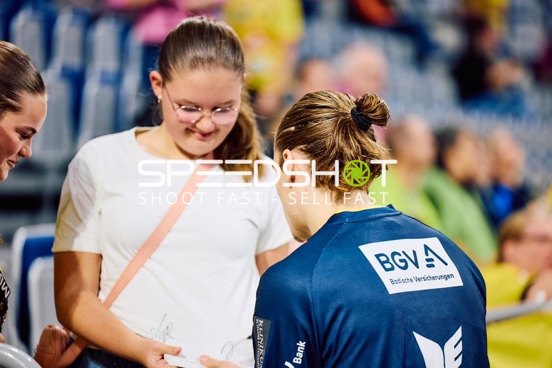 Ein Spieler unterschreibt Autogramme für Fans.