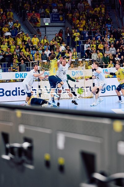 Ein Spieler der Rhein Neckar Löwen versucht, den Wurf eines Spielers des HSV Hamburg zu blocken.