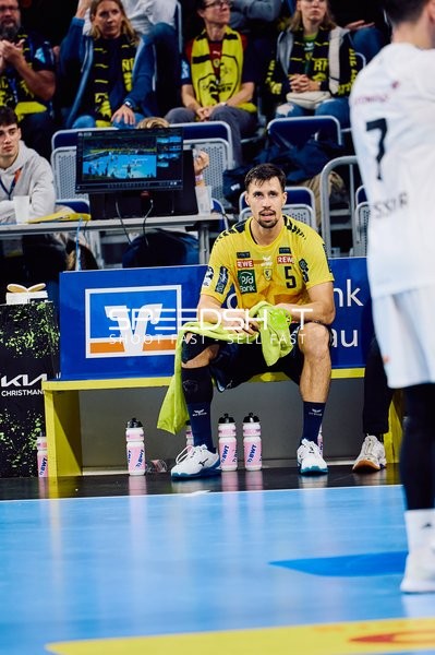 Ein Spieler der Rhein Neckar Löwen mit der Nummer 5 sitzt auf der Bank und beobachtet das Spiel.