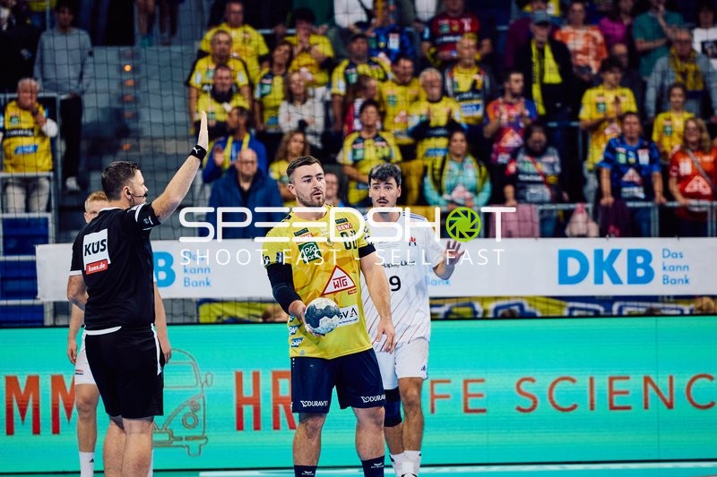 Ein Schiedsrichter zeigt eine Entscheidung an und Jannik Kohlbacher ist mit Spieler der Rhein Neckar Löwen im Fokus.