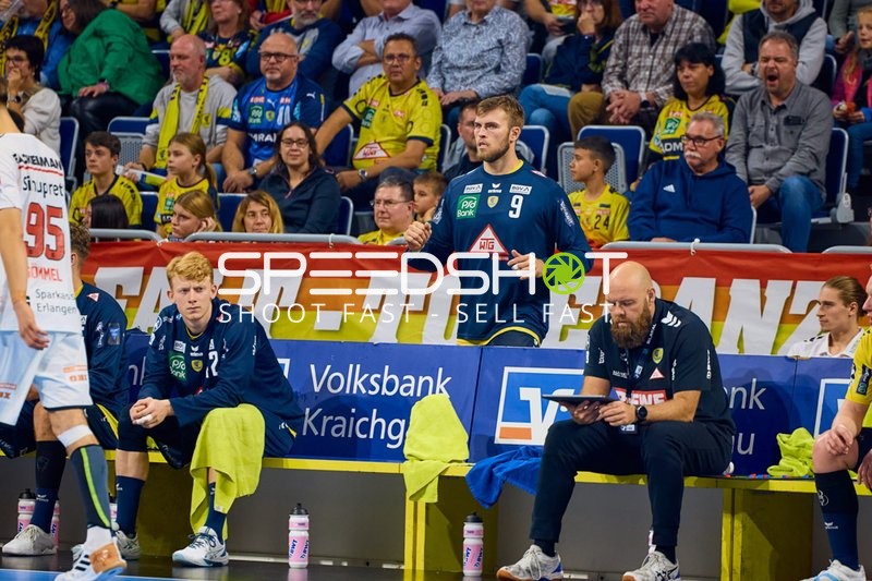 Spieler von Rhein Neckar Löwen beobachten das Spiel von der Bank aus.