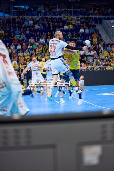 Antonio Metzner von HC Erlangen versucht einen Wurf, während ein Spieler der Rhein Neckar Löwen ihn blockiert.