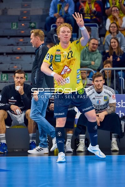 Ein Spieler von Rhein Neckar Löwen mit der Nummer 22 gibt ein Handzeichen auf dem Spielfeld.