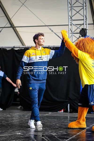 Ein Spieler der Rhein-Neckar Löwen gibt einem Maskottchen einen High-Five.