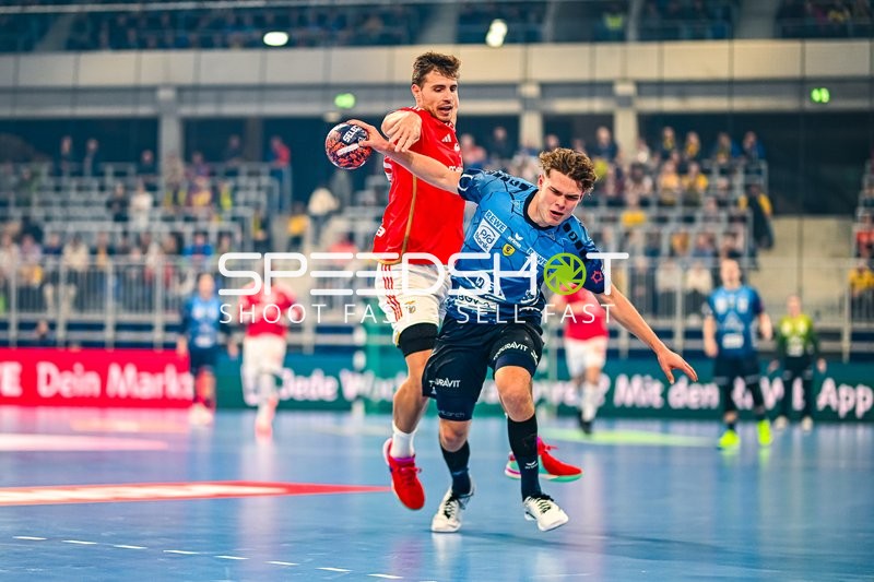 Ein Spieler der Rhein-Neckar Löwen versucht, einen Spieler von Benfica Lissabon im Sprung zu blockieren.