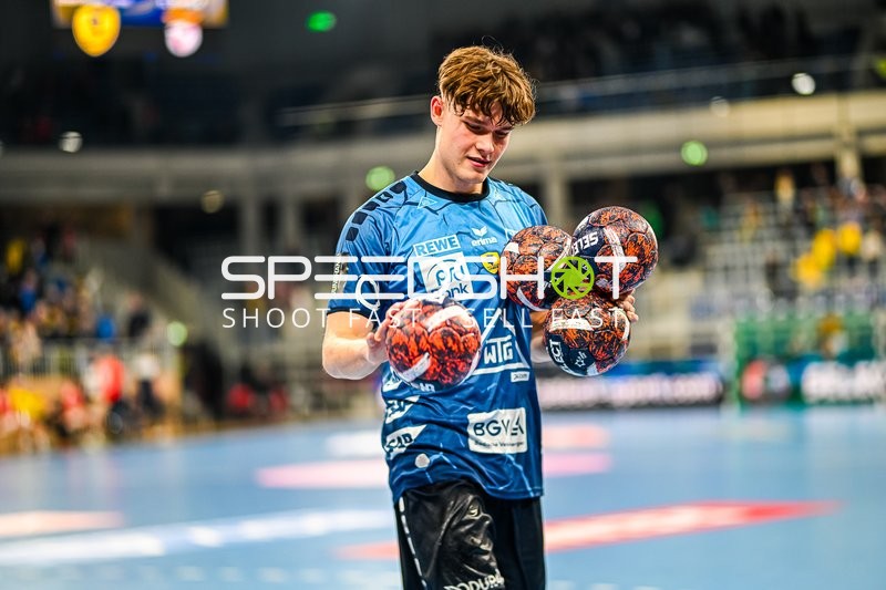 Ein Spieler des Rhein-Neckar Löwen hält mehrere Handbälle in den Armen.