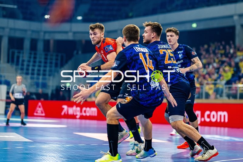 Ein Spieler der Rhein-Neckar Löwen befindet sich im Zweikampf mit einem Gegner, während er versucht, den Ball zu passen oder zu werfen.