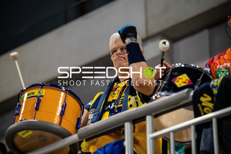 Ein Zuschauer trommelt für das Team während eines Handballspiels.