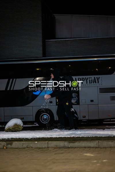 Ein Spieler geht in der Nähe eines Mannschaftsbusses im Schnee.