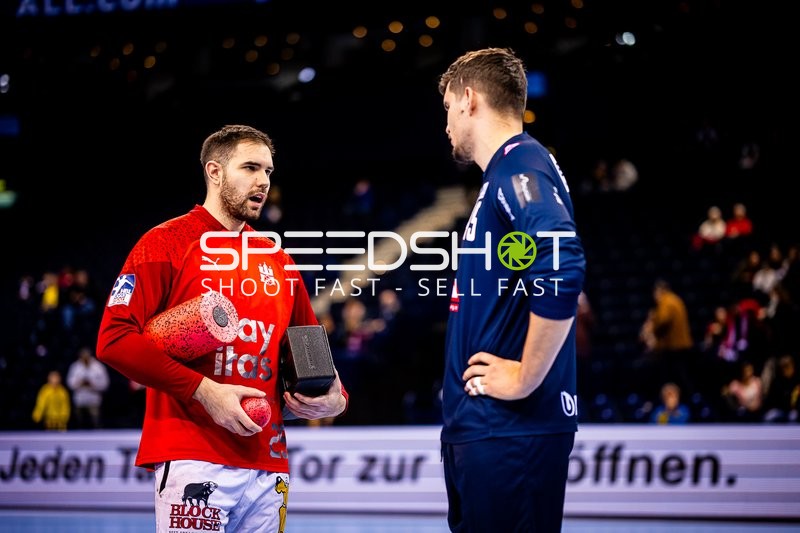 Spieler von Rhein-Neckar Löwen im Gespräch mit einem anderen Spieler auf dem Spielfeld.