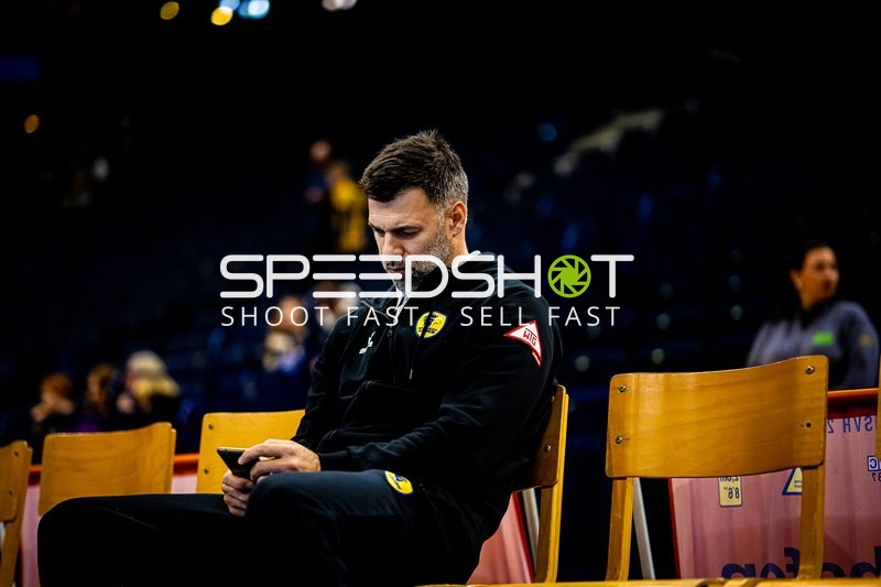 Torwarttrainer nutzt sein Handy vor dem Spiel.