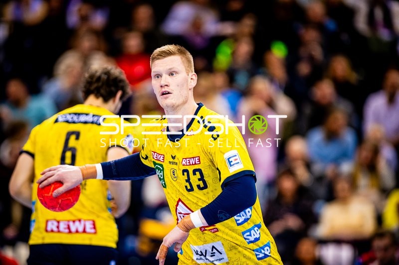 Ein Spieler der Rhein-Neckar Löwen ist im Ballbesitz und bereitet sich vor, den Ball abzugeben oder zu werfen.