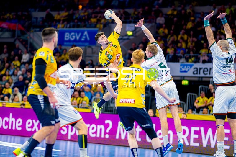 Ein Spieler der Rhein-Neckar Löwen springt für einen Wurf gegen die Abwehr von HSG Wetzlar.