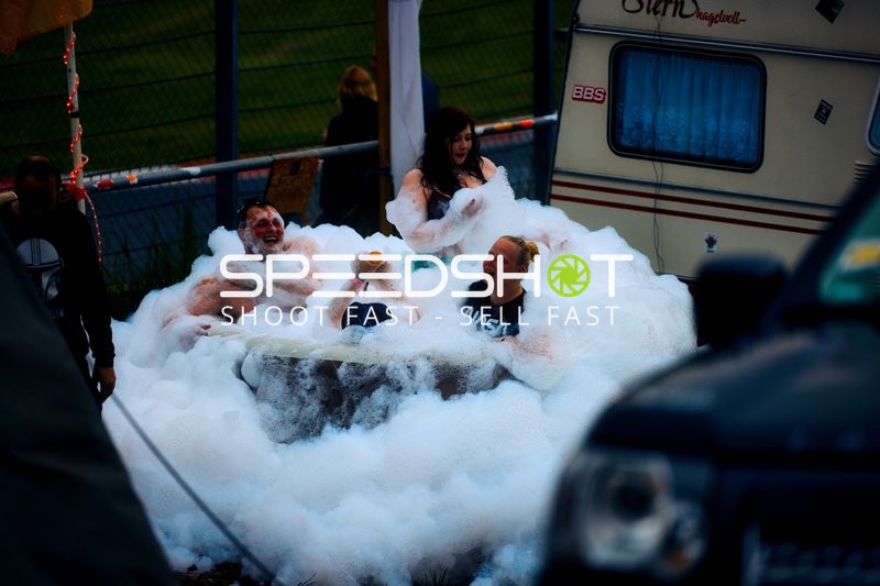 Zuschauer genießen ein Schaumbad neben der Rennstrecke.