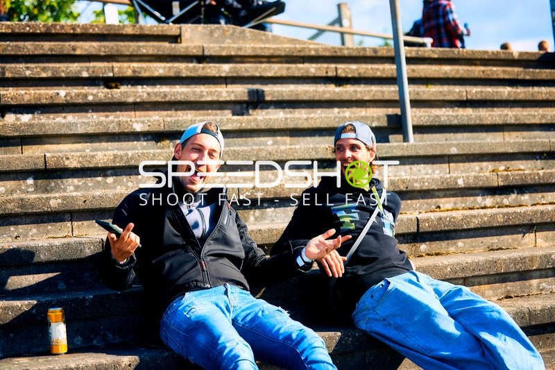 Zwei Personen sitzen auf Treppenstufen und scheinen gut gelaunt zu sein.