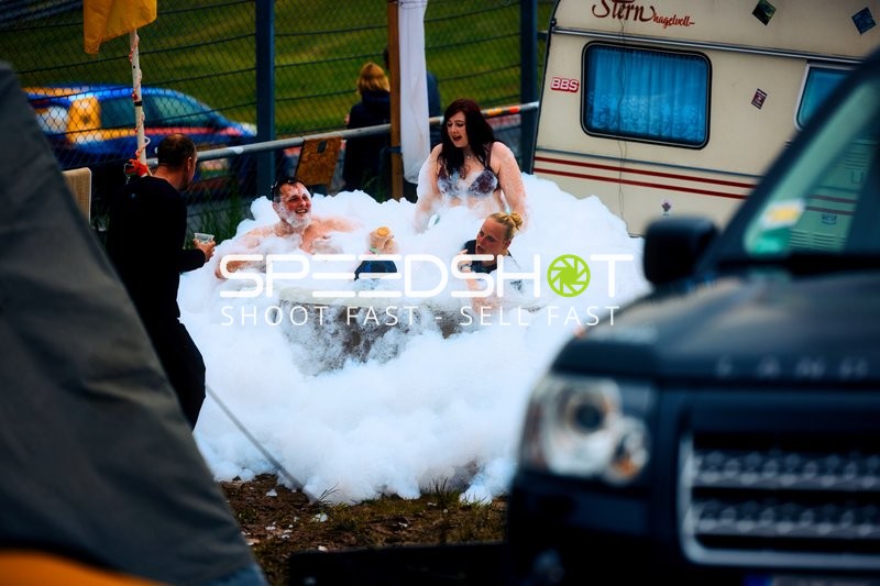 Menschen relaxen in einem Schaumbad neben einem Wohnwagen.