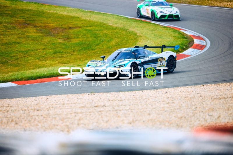 Ein Auto biegt in eine Kurve beim 24h Nürburgring Rennen ein.