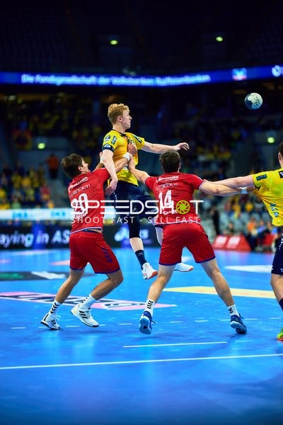 Ein Spieler von Rhein Neckar Löwen springt zum Wurf, während zwei Spieler von SG BBM Bietigheim versuchen zu blocken.